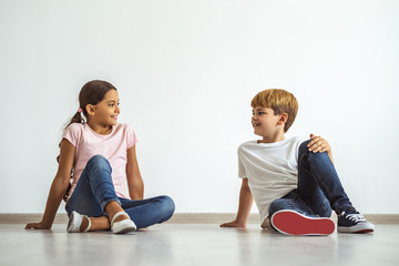 Wall Mural - The happy boy and a girl sitting on the floor