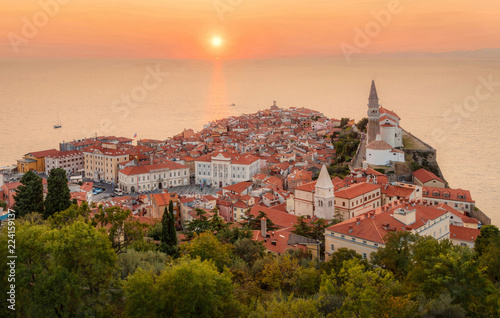 Foto Romantic colorful sunset over picturesque old town Piran with sun on the background, Slovenia