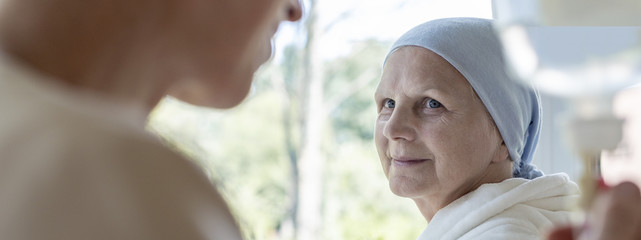 Sticker - Panorama of blurred nurse in the foreground and sick elderly woman with headscarf