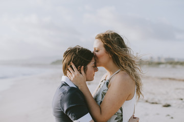 Young couple in love kissing on the deserted beach on a summer evening