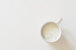 Delicious cup of milk on white with copy space. Top down view.