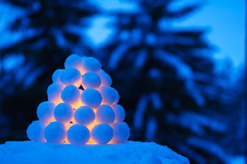 Snowball lantern in winter landscape at dusk.