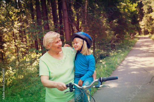 Photographie grandmother teaching little granddaughter to ride bike
