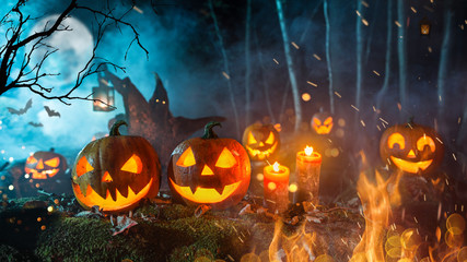 Halloween pumpkins on dark spooky forest.