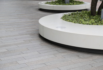 Closeup of designed outdoor circle bench with tree and cement floor.