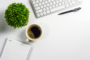 Office desk with coffee cup, blank notebook, black pen, laptop computer and plant pot, top view design