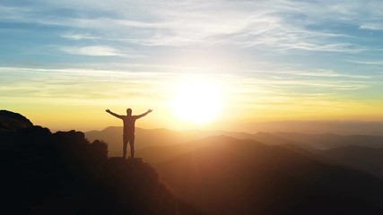Wall Mural - the man standing on the mountain and enjoying the sunrise