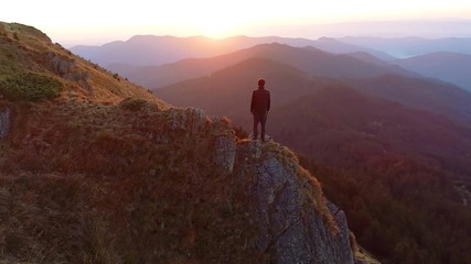 Wall Mural - the man standing on the cliff and enjoying the sunrise