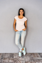 Full body portrait of happy smiling beautiful young woman, isolated over gray background.