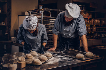 Cooking master class in bakery. Chef with his assistant showing ready samples of baking test in kitchen.