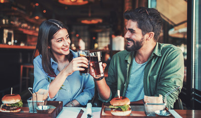 Beautiful young couple sitting in a cafe, having breakfast. Love, food, lifestyle