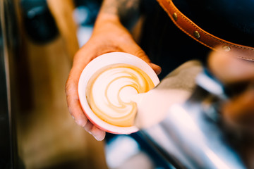 Wall Mural - Professional barista, man making coffee latte art with espresso and foam milk