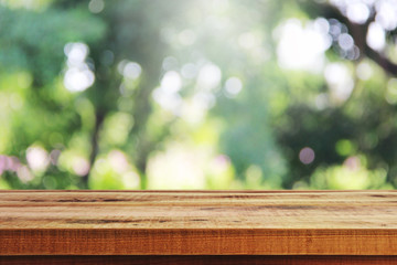 Wall Mural - Wooden table and blurred green garden background.