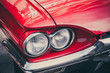 Close-up Of Headlights And Front Bumper On Vintage And Classic American Retro Automobile. Fragment Close Up Detail Of Shiny Red Classic Car With Focus On Headlights And Hood.
