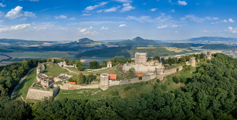 Wall Mural - Aerial panorama of ruined medieval Saris castle in Slovakia with round towers, donjon, walls, and blue sky background