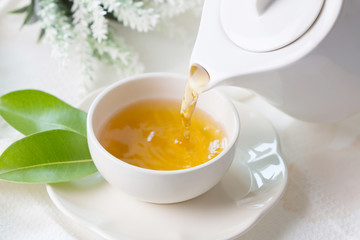 Close up pouring hot black tea in a white tea cup ,  Tea ceremony time concept