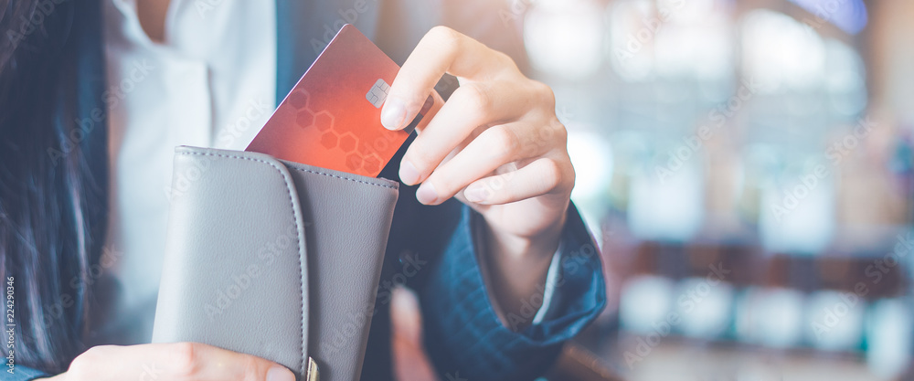 Business women hand Using a credit card, she pulled the card out of her wallet.Web banner. - obrazy, fototapety, plakaty 