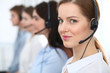 © rogerphoto - Call center. Beautiful cheerful smiling operator consulting clients with headset. Business concept of customer service