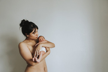 Wall Mural - naked mother holding her infant baby