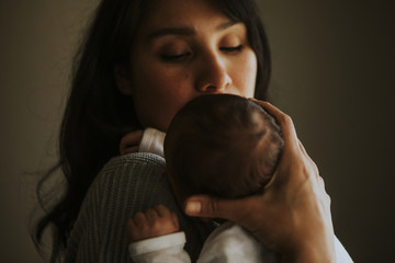 Wall Mural - mother holding her baby indoors
