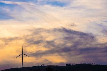 Wind turbine on the hill with cloud sky background.