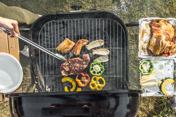 Grilled meat with vegetables over the coals on a barbecue.