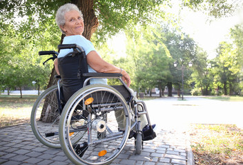 Poster - Senior woman in wheelchair outdoors