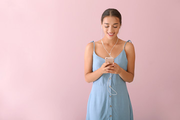 Poster - Beautiful young woman listening to music on color background