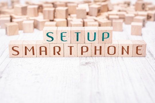 The Words Setup Smartphone Formed By Wooden Blocks On A White Table