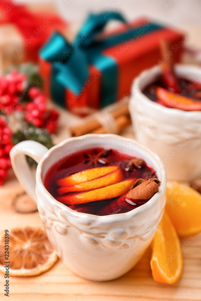 Cup of delicious mulled wine on wooden table
