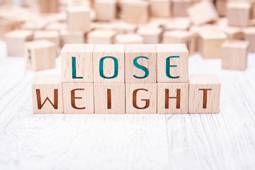 Wall Mural - The Words Lose Weight Formed By Wooden Blocks On A White Table