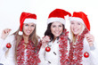 © yurolaitsalbert - closeup.three young women in hats of Santa Claus with Christmas tree balls