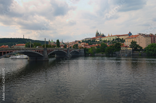 Fotografie, Obraz Scenic view of historical center of Prague, Manes Bridge and Vltava river at cloudy summer day