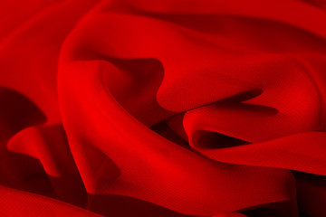 Texture of red silk fabric. Red silk fabric with a soft texture. Sewing fashionable summer clothes.