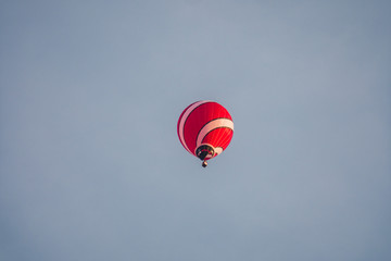 The flying ball with a basket, at the altitude, flies over the city