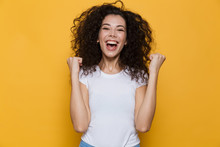 Image Of Young Woman 20s With Curly Hair Yelling And Clenching Fists, Isolated Over Yellow Background