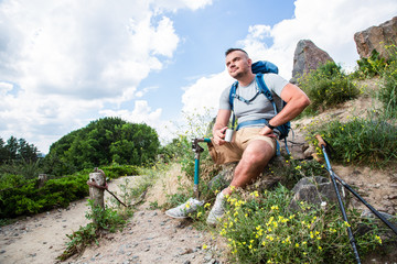 Wall Mural - Low angle of a pleasant male tourist having a rest outdoors