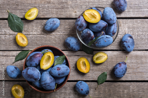 Fotografía Fresh plums in bowl on wooden table