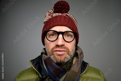 Fotografía Close up portrait of middle aged europeam man in funny warm hat and glasses noticing hidden camera