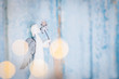 White angel Christmas decoration on blue background with lights