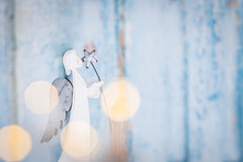 White Angel Christmas Decoration On Blue Background With Lights