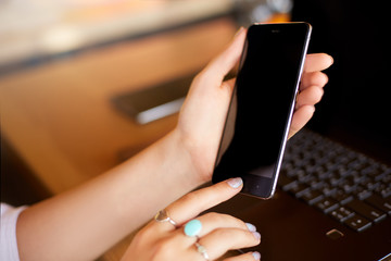 Wall Mural - female scanning fingerprint on her smartphone with laptop on backround. woman unlock mobile phone wi