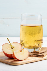 One glass of apple juice and fresh apple on white background.