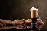 Coffee drink or cocktail with cream on a black background.