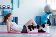 Sportswoman on mat doing exercises with broken leg during rehabilitation