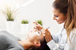 © Kalim - Adult woman having eyelash extension in professional beauty salon