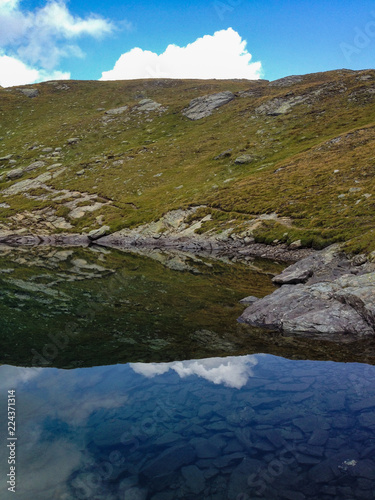 Fotografía panoramic view of an alpine lake, where the Swiss mountains are mirrored at the Simplon pass