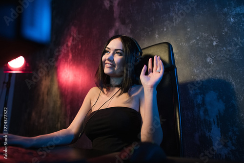 Fotografie, Obraz A cute female gamer girl sits in a cozy room behind a computer and plays games