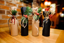 Four Adorable Christmas Decorated Bottles With Ribbons And Fir-tree Branch