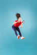 © master1305 - Beautiful young woman jumping with megaphone isolated over red background. Runnin girl in motion or movement. Human emotions and facial expressions concept